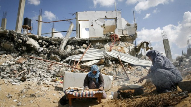 أمرأة فلسطينية تخبز الخبز وسط أنقاض منزلها المدمر في مدينة خان يونس، جنوبي قطاع غزة، 21 سبتمبر، 2014. (Abed Rahim Khatib/Flash90) أمرأة فلسطينية تخبز الخبز وسط أنقاض منزلها المدمر في مدينة خان يونس، جنوبي قطاع غزة، 21 سبتمبر، 2014. (Abed Rahim Khatib/Flash90)