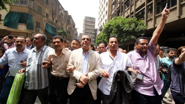 نقيب الصحافيين يحيي قلاش وسكرتير عام النقابة جمال عبد الرحيم ورئيس لجنة الحريات خالد البلشي خلال مسيرة احتجاجية بعد مغادرة المحكمة في القاهرة، 4 يونيو 2016 (STR / AFP)