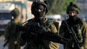 من الأرشيف: جنود إسرائيليون يقومون بدورية في شارع، شرقي غرب مدينة نابلس في الضفة الغربية، 3 أكتوبر، 2015، خلال عمليات بحث عن فلطسيني مشتبه به بقتل الزوجين الإسرائيليين إيتام ونعمة هينكين. (AFP PHOTO/JAAFAR ASHTIYEH)