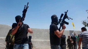 مسلحون فلسطينيون يطلقون الرصاص في الهواء خلال تشييع جثمان ثلاثة رجال قتلوا برصاص جنود اسرائيليين في مخيم قلنديا، بالقرب من رام الله، 26 اغسطس 2013 (Issam Rimawi/Flash90)