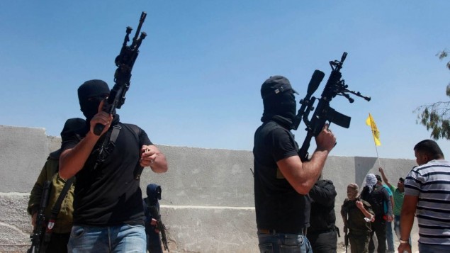مسلحون فلسطينيون يطلقون الرصاص في الهواء خلال تشييع جثمان ثلاثة رجال قتلوا برصاص جنود اسرائيليين في مخيم قلنديا، بالقرب من رام الله، 26 اغسطس 2013 (Issam Rimawi/Flash90)