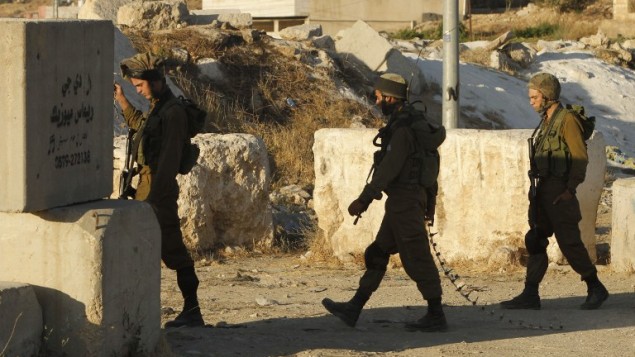صورة توضيحية: جنود اسرائيليون يقيمون حاجزا امنيا عند المدخل الجنوبي لمدينة الخليل في الضفة الغربية، 2 يوليو 2016 (HAZEM BADER / AFP)