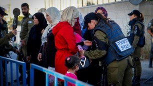 فلسطينيون يخضعون لتفتيش أمني عند حاجز في مدينة بيت لحم في الضفة الغربية، خلال توجههم إلى المسجد الأقصى في القدس للمشاركة في صلاة الجمعة الأولى من شهر رمضان، 10 يونيو، 2016. (Wisam Hashlamoun/Flash90)