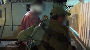 الجيش الإسرائيلي يعتقل رجلا خلال مداهمة في الضفة الغربية لإعتقال أعضاء خلية تابعة لحركة حماس تقف وراء قتل الحاخام ميكي مارك، 27 يوليو، 2016. (لقطة شاشة: YouTube)