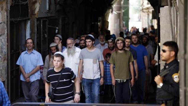 قوات الأمن الإسرائيلية تحرس مجموعة من الرجال اليهودبعد إنهائهم لزيارة للحرم القدسي، خلال إحياء ذكرى ’التاسع من آب’، 14 أغسطس، 2016. (AFP PHOTO/AHMAD GHARABLI) قوات الأمن الإسرائيلية تحرس مجموعة من الرجال اليهودبعد إنهائهم لزيارة للحرم القدسي، خلال إحياء ذكرى ’التاسع من آب’، 14 أغسطس، 2016. (AFP PHOTO/AHMAD GHARABLI)