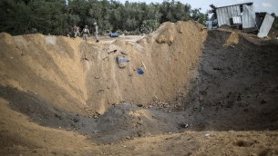 نقاتلين من الجهاد الإسلامي يفحصون موقع سقوط صاروخ في بيت لاهيا، شمال قطاع غزة، 22 اغسطس 2016 (MAHMUD HAMS / AFP)