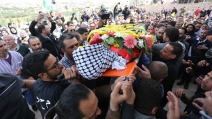 مشيعون فلسطينيون يهتفون شعارات خلال حملهم لجثمان محمود شعلان (17 عاما) خلال جنازته في قرية دير دبوان، بالقرب من مدينة رام الله في الضفة الغربية، 2 مارس، 2016. (Photo by Flash90)