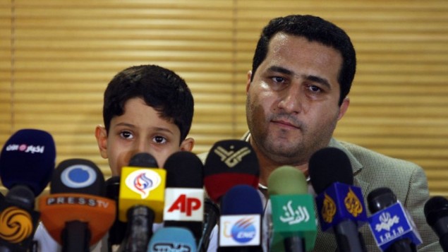 Shahram Amiri, an Iranian nuclear scientist attends a news briefing while holding his son Amir Hossein as he arrives at the Imam Khomeini airport just outside Tehran, Iran, after returning from the United States on July 15, 2010. AP/Vahid Salemi