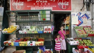 طفلتان تأكلان البوظة خلال مغادرتهما لميني ماركت في القدس، 2 أغسطس، 2010.  (Miriam Alster/Flash90)