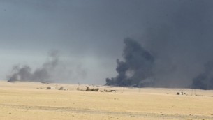 سحب الدخان تتصاعد من آبار النفط المشتعلة كما تظهر من قاعدة القيارة العسكرية، على بعد 60 كيلومترا من مدينة الموصل، في 16 أكتوبر، 2016، في الوقت الذي تستعد فيه القوات العراقية لشن عملية لإستعادة المدينة من تنظيم ’الدولة الإسلامية’، آخر معاقل التنظيم في العراق. (AFP PHOTO / AHMAD AL-RUBAYE)