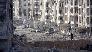 عناصر من القوات الموالية للنظام السوري تقف وسط مبان تضررت بشكل كبير في منطقة ’1070 شقة’ في 8 نوفمبر، 2016، بعد أن إستعادتها من عناصر المتمردين. ( AFP PHOTO / GEORGES OURFALIAN)