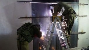 جنود إسرائيليون يغلقون ورشطة عمل يُزعم أنها استخدمت لصنع أسلحة غير قانونية في يطا، القريبة من الخليل، فجر 8 نوفمبر، 2016. (وحدة المتحدث بإسم الجيش الإسرائيلي)
