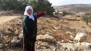 إمرأة فلسطينية تشير إلى الأرض التي تقول إنها كانت ملكا لعائلتها قبل أن تقوم إسرائيل بإنشاء مستوطنة عامونا في عام 1996، نوفمبر 2016. (Raphael Ahren/Times of Israel)