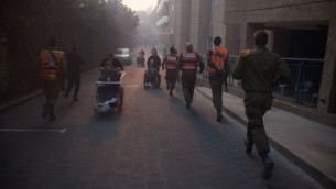 الجنود من قيادة الجبهة الداخلية التابعة للجيش الإسرائيلي يساعدون في عمليات الإخلاء في حيفا جراء حريق هائل أجتاح أجزاء من المدينة، 24 نوفمبر، 2016. (IDF Spokesperson's Unit)