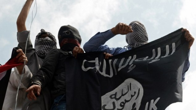 صورة توضيحية لرجال يحملون راية تنظيم الدولة الإسلامية (AFP/Tauseef Mustafa)