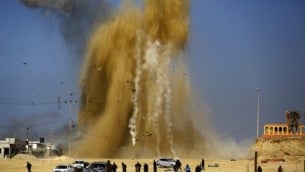 الفلسطينيون يبحثون عن مخبأ مع تصاعد الرمال والدخان في أعقاب غارة جوية إسرائيلية ضد موقع تابع لحركة ’حماس’ شمال قطاع غزة، 6 فبراير، 2017. (Mohammed Abed/AFP)