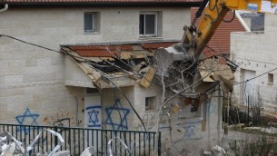 جرافة تهدم منزلا مبنيا على ارض فلسطينية خاصة في مستوطنة عوفرا بالضفة الغربية، 1 مارس 2017 (AFP Photo/Menahem Kahana)