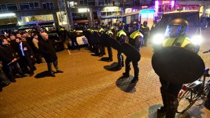 عناصر شرطة تواجه متظاهرين احتشدوا أمام القنصلية التركية في روتردام في 11 مارس، 2017. (AFP PHOTO / EMMANUEL DUNAND)