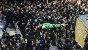 عناصر من كتائب عز الدين القسام، الجناح العسكري لحركة حماس، يشيعون جثمان مازن الفقهاء خلال جنازته في مدينة غزة، 25 مارس، 2017. (AFP PHOTO / MAHMUD HAMS)