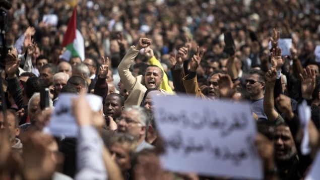 نوظفو السلطة الفلسطينية يطلقون هتافات ويلوحون بلافتات خلال تظاهرة ضد قرار السلطة الفلسطينية بخفض رواتبهم في مدينة غزة، 8 أبريل، 2017. (AFP Photo/Mahmud Hams) نوظفو السلطة الفلسطينية يطلقون هتافات ويلوحون بلافتات خلال تظاهرة ضد قرار السلطة الفلسطينية بخفض رواتبهم في مدينة غزة، 8 أبريل، 2017. (AFP Photo/Mahmud Hams)