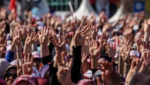 الجماهير تهتف وترفع شعار الأصابع الأربعة الذي يرمز لشعار "رابعة" خلال إلقاء الرئيس التركي لخطال في إسطنبول، 15 أبريلن 15 أبريل، 2017، خلال تجمع عشية الإستفتاء الدستوري. (Ozan Kose/AFP)