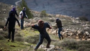 صورة للتوضيح: متظاهرون شبان يهود يلقون الحجارة على قوات الشرطة في بؤرة عامونا الإستيطانية غير القانونية، 1 فبراير، 2017، في صباح إخلاء المستوطنة. (Hadas Parush/Flash90)