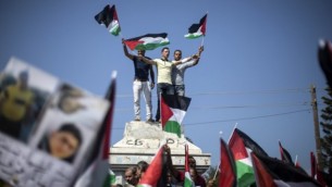 فلسطينيون في غزة يلوحون  بأعلام فلسطينية خلال تظاهرة دعما للوحدة الوطنية في 22 أكتوبر، 2016 في مدينة غزة. (AFP PHOTO / MAHMUD HAMS)