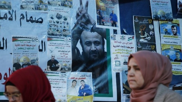 نساء فلسطينيان امام ملصق عليه صورة الاسير الفلسطيني المضرب عن الطعام مروان البرغوثي في رام الله، 24 ابريل 2017 (AFP/Abbas Momani) نساء فلسطينيان امام ملصق عليه صورة الاسير الفلسطيني المضرب عن الطعام مروان البرغوثي في رام الله، 24 ابريل 2017 (AFP/Abbas Momani)