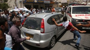متظاهرون فلسطينيون يحيطون بسيارة مستوطن اسرائيلي حاول المرور وسط مظاهرة بالقرب من حاجز حوارة العسكري في شمال الضفة الغربية، 18 مايو 2017 (AFP Photo/Jaafar Ashtiyeh)