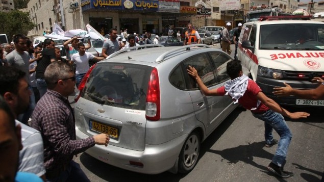 متظاهرون فلسطينيون يحيطون بسيارة مستوطن اسرائيلي حاول المرور وسط مظاهرة بالقرب من حاجز حوارة العسكري في شمال الضفة الغربية، 18 مايو 2017 (AFP Photo/Jaafar Ashtiyeh)