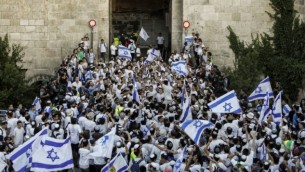 اسرائيليون يلوحون بالاعلام الإسرائيلية في باب العامود، خلال مسيرة احتفال بيوم القدس، في الذكرى الخمسين لتوحيد المدينة بعد حرب 1967، 24 مايو 2017 (AFP PHOTO / Thomas COEX)