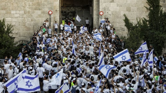 اسرائيليون يلوحون بالاعلام الإسرائيلية في باب العامود، خلال مسيرة احتفال بيوم القدس، في الذكرى الخمسين لتوحيد المدينة بعد حرب 1967، 24 مايو 2017 (AFP PHOTO / Thomas COEX)