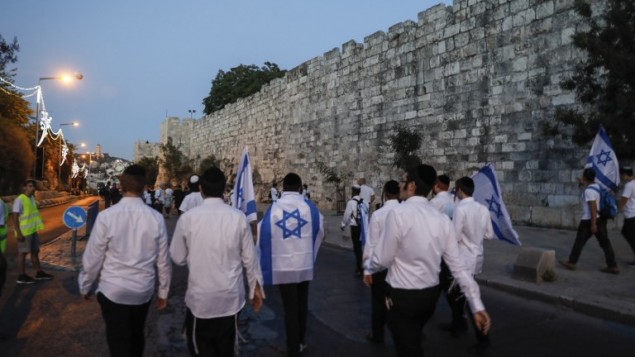 اسرائيليون يلوحون بالاعلام الإسرائيلية خلال مسيرة حول القدس القديمة، احتفال بيوم القدس، في الذكرى الخمسين لتوحيد المدينة بعد حرب 1967، 24 مايو 2017 (AFP PHOTO / Menahem KAHANA)