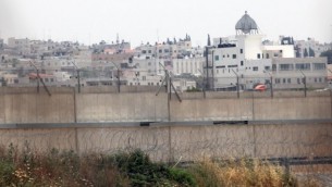 مدينة قلقيلية في الضفة الغربية في صورة لها من وراء الجدار الفاصل الإسرائيلي. (Yossi Zamir/Flash90)