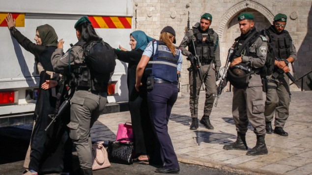عناصر قوات امن اسرائيليين يفتشون نساء فلسطينيان امام باب العامود في القدس القديمة، قبل السماح لهن الصعود على متن حافلة متجهة الى الضفة الغربية، 17 يونيو 2017 (Sliman Khader/Flash90)
