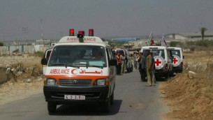 أعضاء في جمعية الصليب الأحمر يعملون على تأمين نقل مرضى فسلطينيين عند معبر إيرز في 19 يونيو، 2007. (Ahmad Khateib/ Flash90)