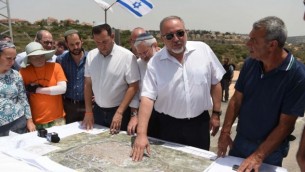 وزير الدفاع أفيغدور ليبرمان يعرض خطته للسماح للفلسطينيين بتوسيع مدينة قلقيلية في الضفة الغربية إلى أراض تخضع للسيادة الإسرائيلية حاليا، خلال جولة في مستوطنة معاليه شومرون، 12 يوليو، 2017. (Eden Moldavski/Defense Ministry)