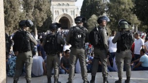 قوى الأمن الإسرائيلية تقف أمام المصلين الفلسطينين في الحرم القدسي في 27 يوليو، 2017، مع المسجد الأقصى في الخلفية. (AFP PHOTO / AHMAD GHARABLI)