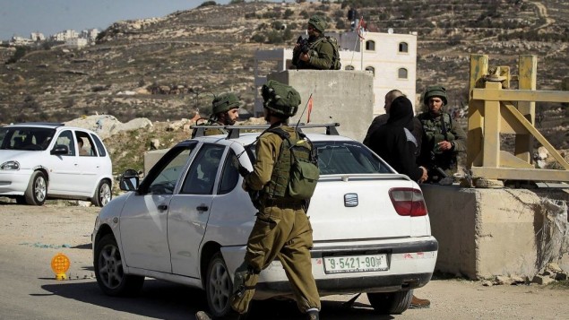 صورة توضيحية: جنود اسرائيليون يفتشون سيارات فلسطينية في حاجز في بلدة يطا بالضفة الغربية، 10 فبراير 2017 (Wisam Hashlamoun/Flash90)