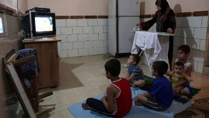 امرأة فلسطيية تقوم بكي الثياب خلال الساعات القليلة من الكهرباء التي تحصل عليها غزة في كل يوم، في مخيم رفح جنوب قطاع غزة، 31 يوليو، 2017. (AFP/ SAID KHATIB)