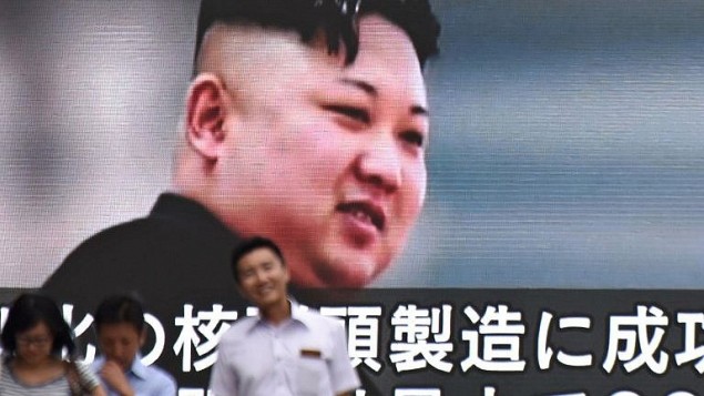 صورة لاشخاص يمرون امام شاشة في طوكيو تعرض صورة للقائد الكوري الشمالي كيم جون أون، في 9 اغسطس 2017 (AFP PHOTO / Kazuhiro NOGI)