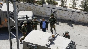 صورة تم التقاطها في 26 سبتمبر، 2017، في قرية بيت سوريك في الضفة الغربية تظهر جنودا إسرائيليين يقومون باعتقال فلسطيني، أشارت تقارير إلى أن شقيقه قام بارتكاب هجوم أسفر عن مقتل ثلاثة إسرائيليين في مستوطنة هار أدار. (AFP PHOTO / ABBAS MOMANI)