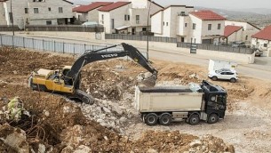 عمال فلسطينيون يعملون في موقع بناء مشروع سكني جديد في مستوطنة أريئيل القريبة من مدينة نابلس في الضفة الغربية، 25 يناير، 2017. (AFP Photo/Jack Guez)