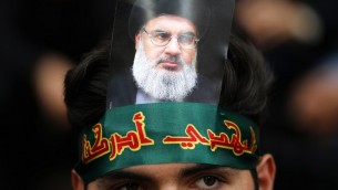 مؤيد لمنظمة ’حزب الله’ يضع على رأسه صورة للأمين العام للمنظمة حسن نصر الله خلال إحياء  ’يوم عاشوراء’ في الضاحية الجنوبية للعاصمة اللبنانية بيروت، 1 أكتوبر، 2017. ( AFP PHOTO / ANWAR AMRO)