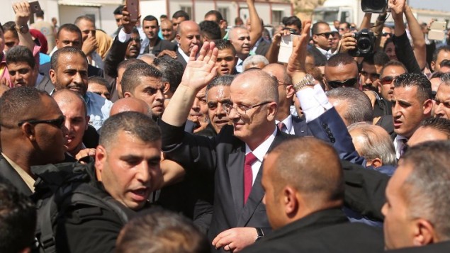 رئيس الحكومة الفلسطيني رام الحمد الله (وسط الصورة) محاط برجال الأمن عند وصوله إلى معبر إيريز الحدودي في بيت حانون شمال قطاع غزة، 2 أكتوبر، 2017، في زيارة أولى إلى القطاع لإجراء محادثات تهدف إلى التوصل إلى اتفاق مصالحة بين حركتي فتح وحماس. (AFP PHOTO / MAHMUD HAMS)