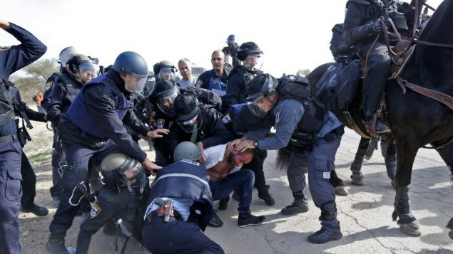 عناصر الشرطة الإسرائيلية تعتقل رجلا بدويا خلال مظاهرات ضد هدم منازل في قرية ام الحيران البدوية غير المعترف بها، 18 يناير 2017 (AFP/AHMAD GHARABLI)
