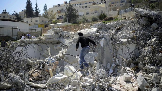 صورة توضيحية لرجل فلسطيني فوق حطام منزل تم هدمه في حي الطور في القدس الشرقية، 26 مارس 2014 (Sliman Khader/Flash90)