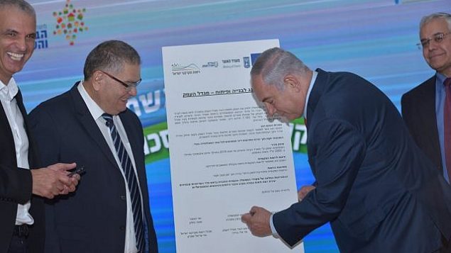 رئيس الوزراء بينيامين نتنياهو (من اليمين) يوقع على اتفاق لمشروع سكني جديد في مدينة مجدال هعيمق شمال البلاد، 6 نوفمبر، 2017. (Migdal Haemek)