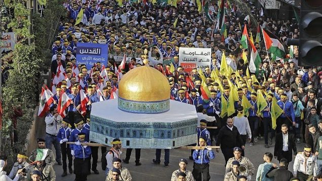 انصار تنظيم حزب الله اللبناني يحملون مجسما للمسجد الاقصى ويلوحون بالاعلام اللبنانبة، الفلسطينية وواعلام حزب الله خلال مظاهرة في بيروت، 11 ديسمبر 2017 (AFP Photo/Joseph Eid) انصار تنظيم حزب الله اللبناني يحملون مجسما للمسجد الاقصى ويلوحون بالاعلام اللبنانبة، الفلسطينية وواعلام حزب الله خلال مظاهرة في بيروت، 11 ديسمبر 2017 (AFP Photo/Joseph Eid)