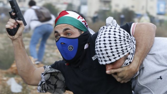 شرطي اسرائيلي مستعرب يعتقل متظاهرا فلسطينيا خلال مواجهات في مدينة رام الله في الضفة الغربية، 13 ديسمبر 2017 (Abbas Momani/AFP)
